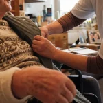 Fiche metier auxiliaire de vie : auxiliaire de vie aide à enfiler une veste au domicile