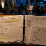 Projet d'animation : documents et planning au bureau, salle d’accueil en arrière-plan floue